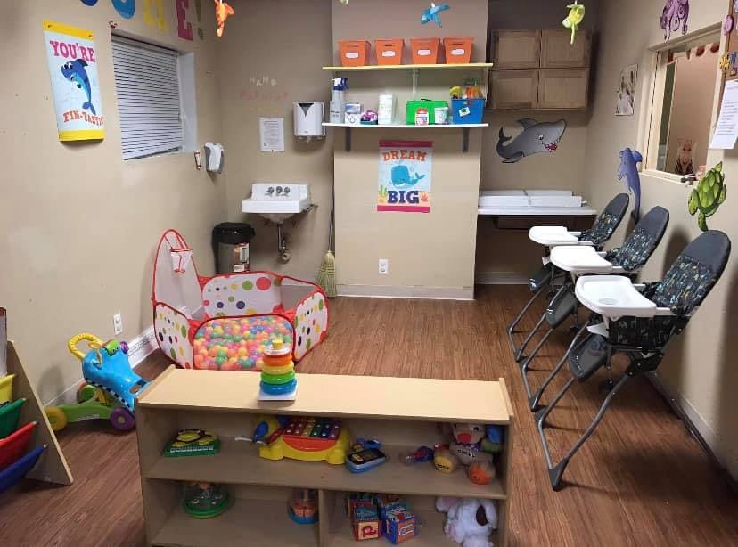 Daycare room with high chairs, ball pit, and changing station