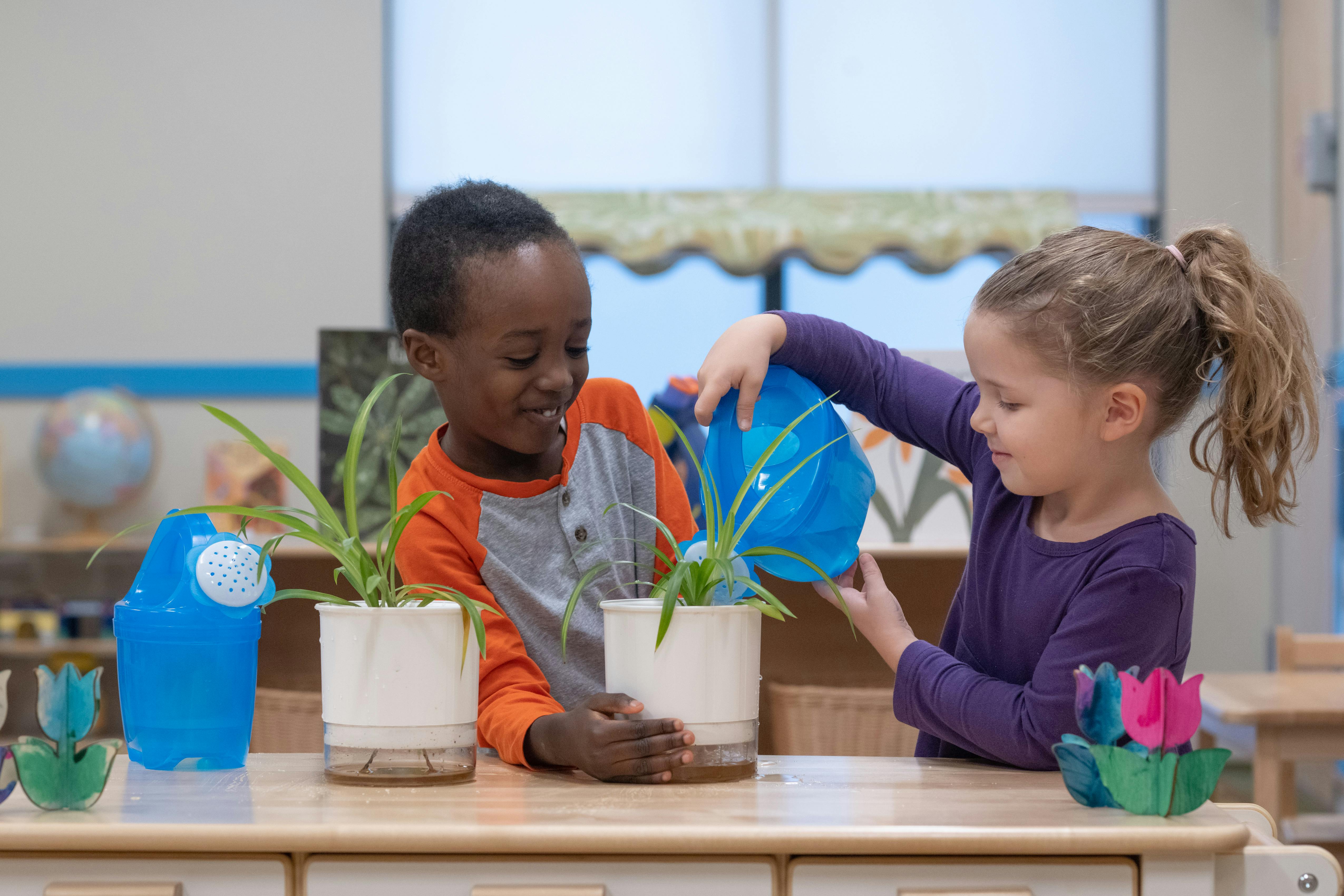 Two children watering plants in pots