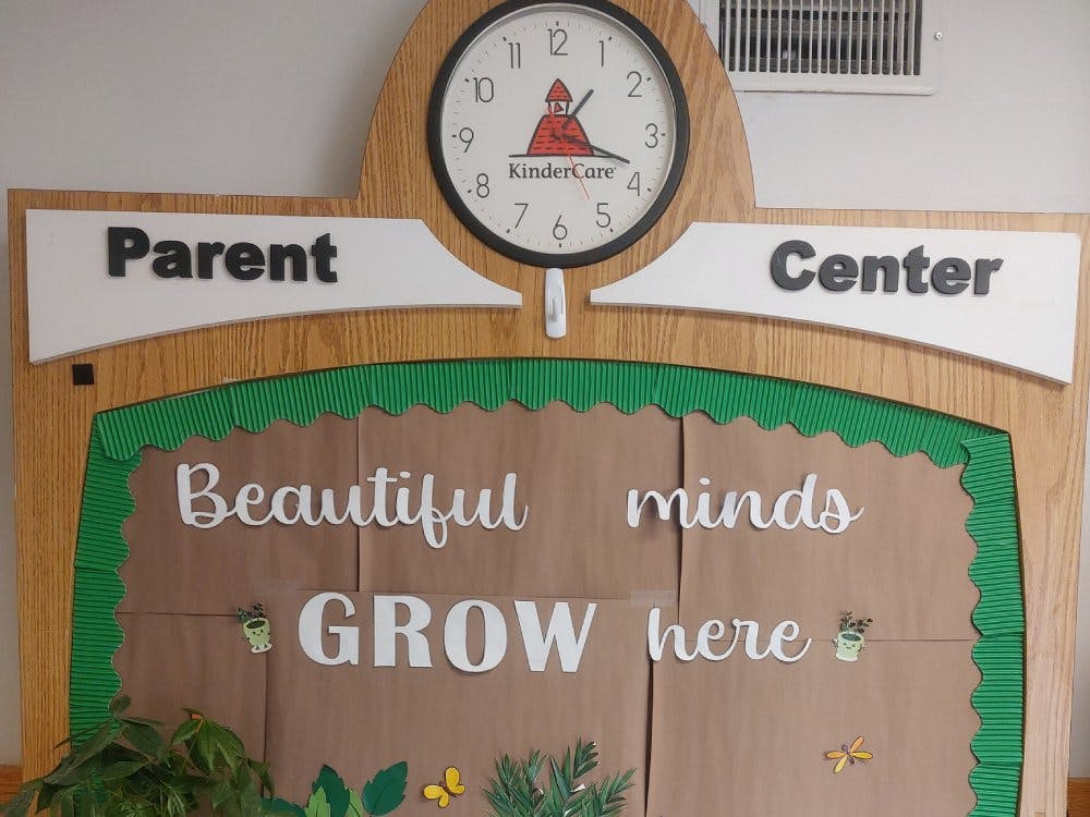 Parent Center bulletin board with clock and "Beautiful minds GROW here" text