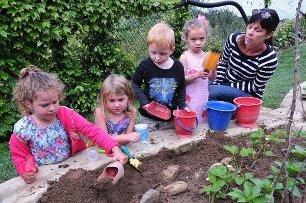 Adult and children planting in a garden