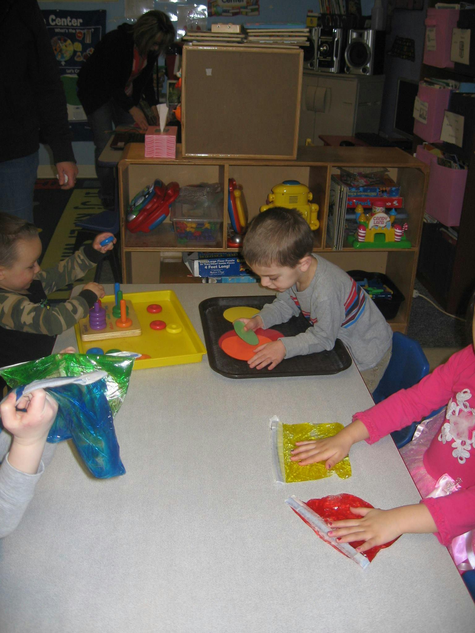 Children playing with toys at a table in a classroom