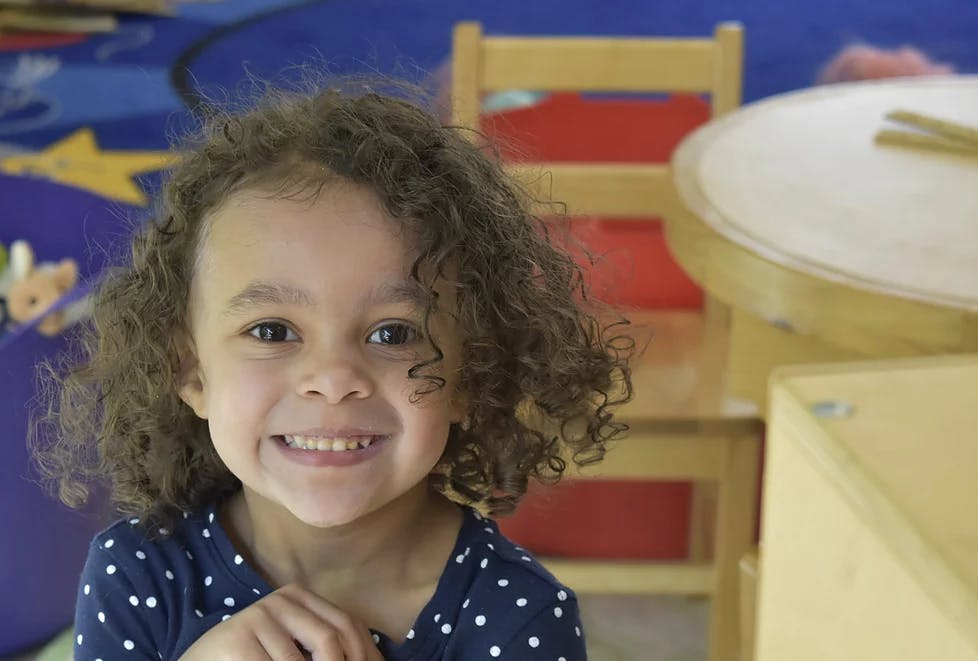 Child with curly hair smiling