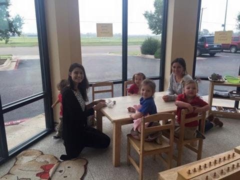 Two people and four children sitting at a small table