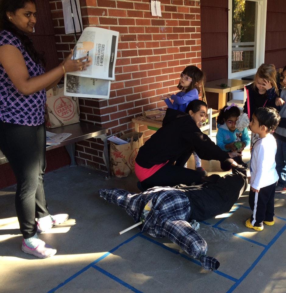 People and children gathered around a scarecrow