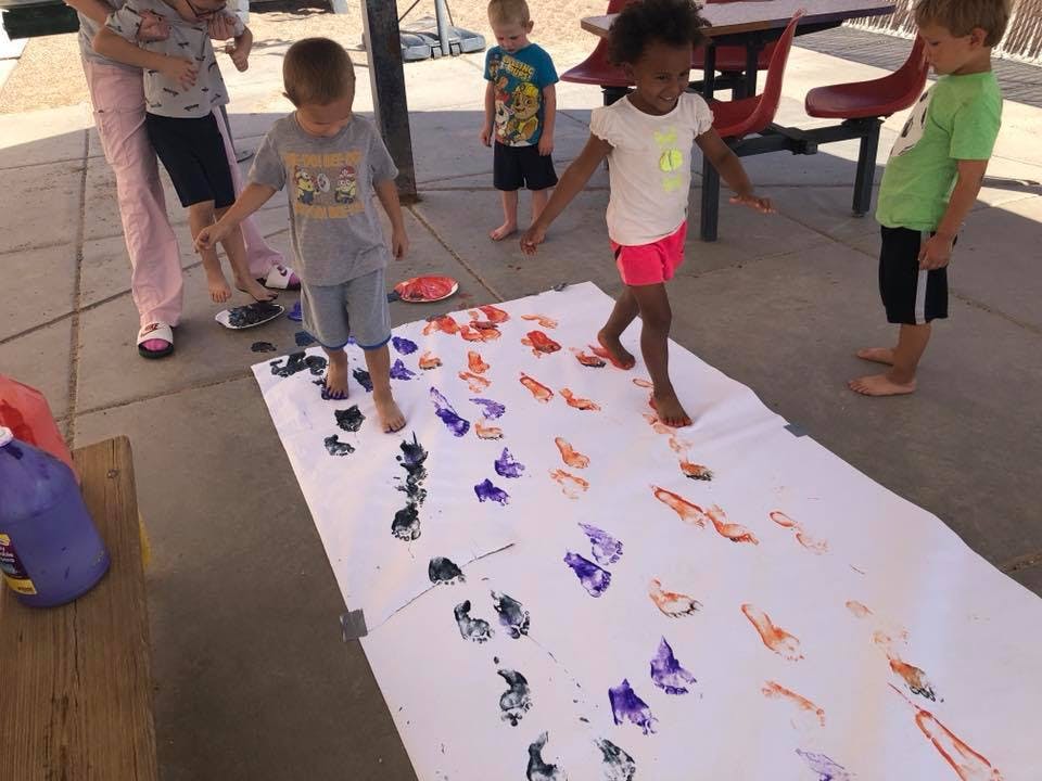 Children making footprints on a long sheet of paper