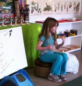 Child sitting on a stool in a classroom