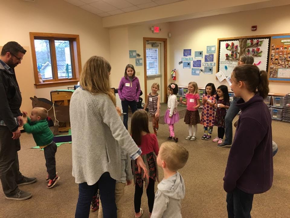 Adults and children standing in a room