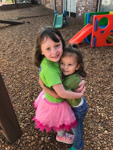 Two children hugging on a playground