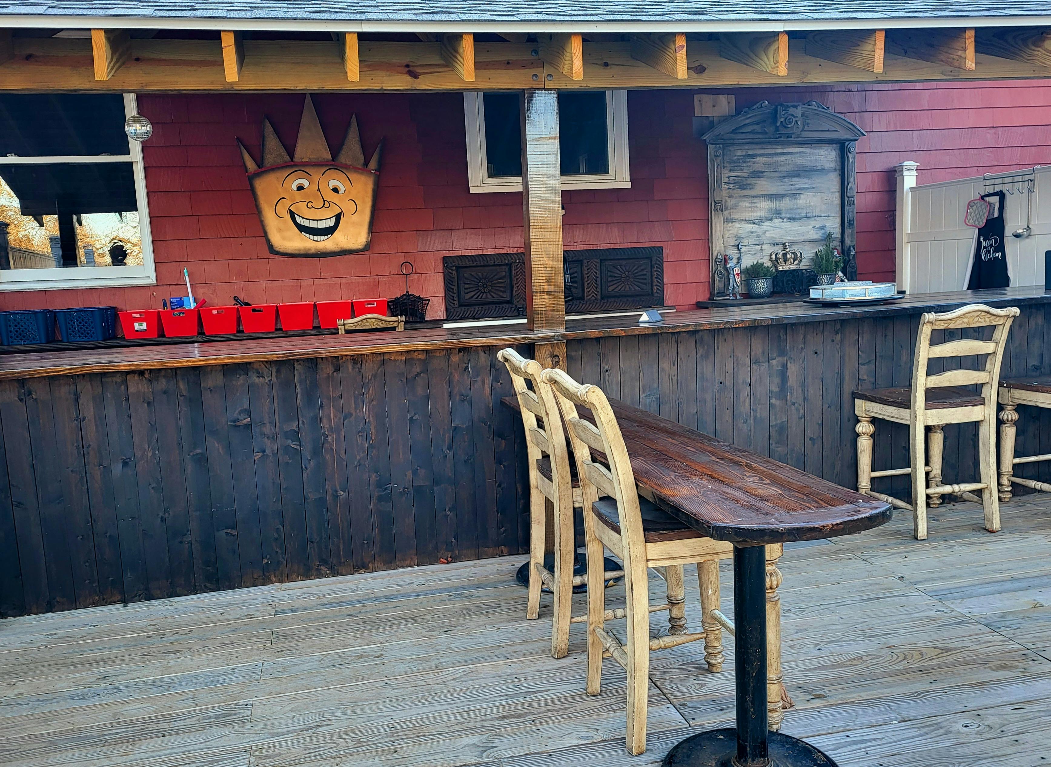 Outdoor bar area with wooden counter and stools