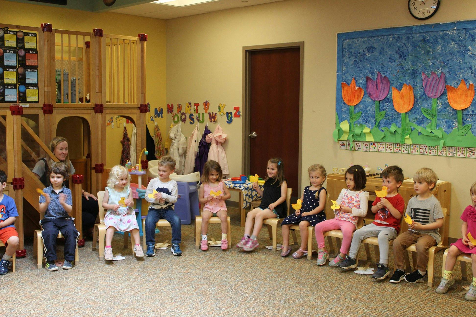 Children sitting in chairs in a classroom