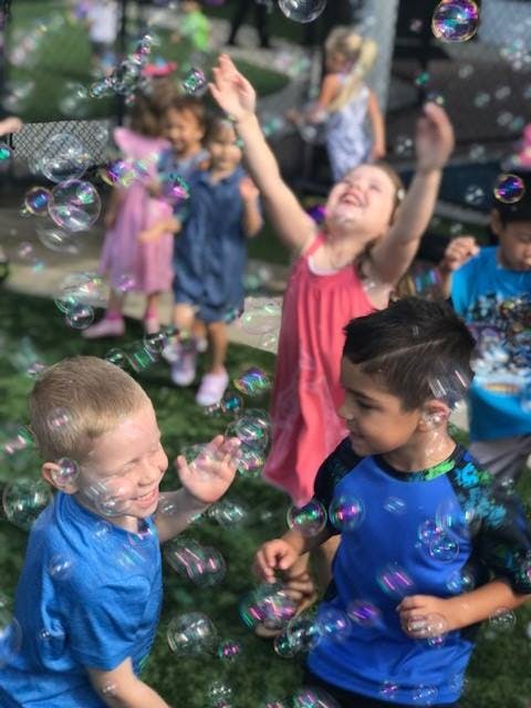 Children playing with bubbles outdoors