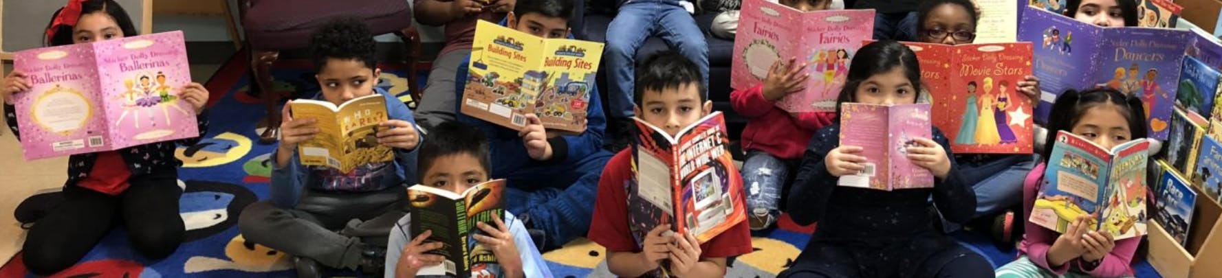 Group of children reading books in a classroom