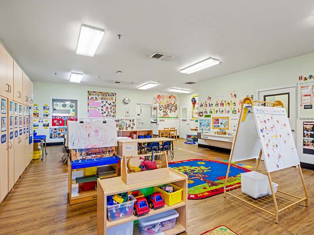 Classroom with child-sized furniture, art on walls, and play areas