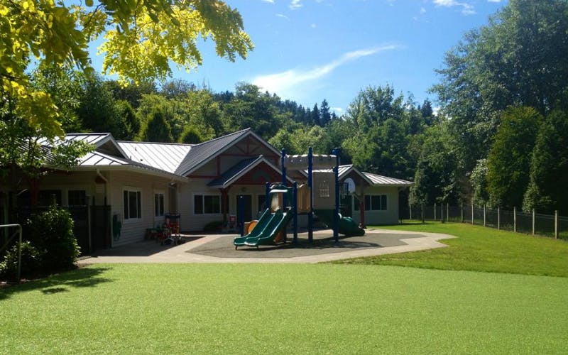 Playground with slides and climbing structure outside a building