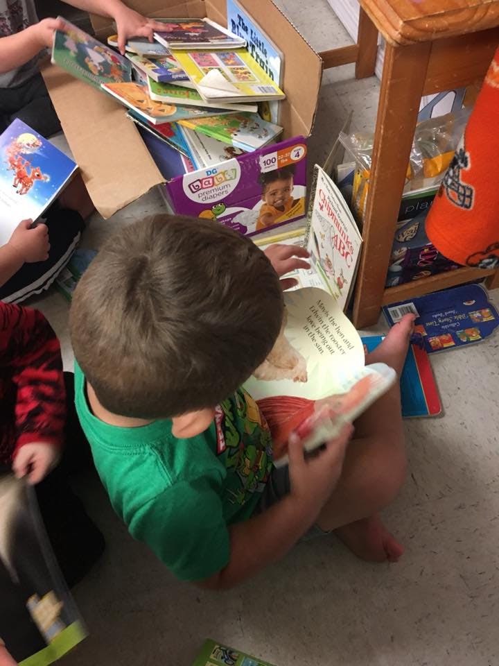 Child sitting on floor reading a book