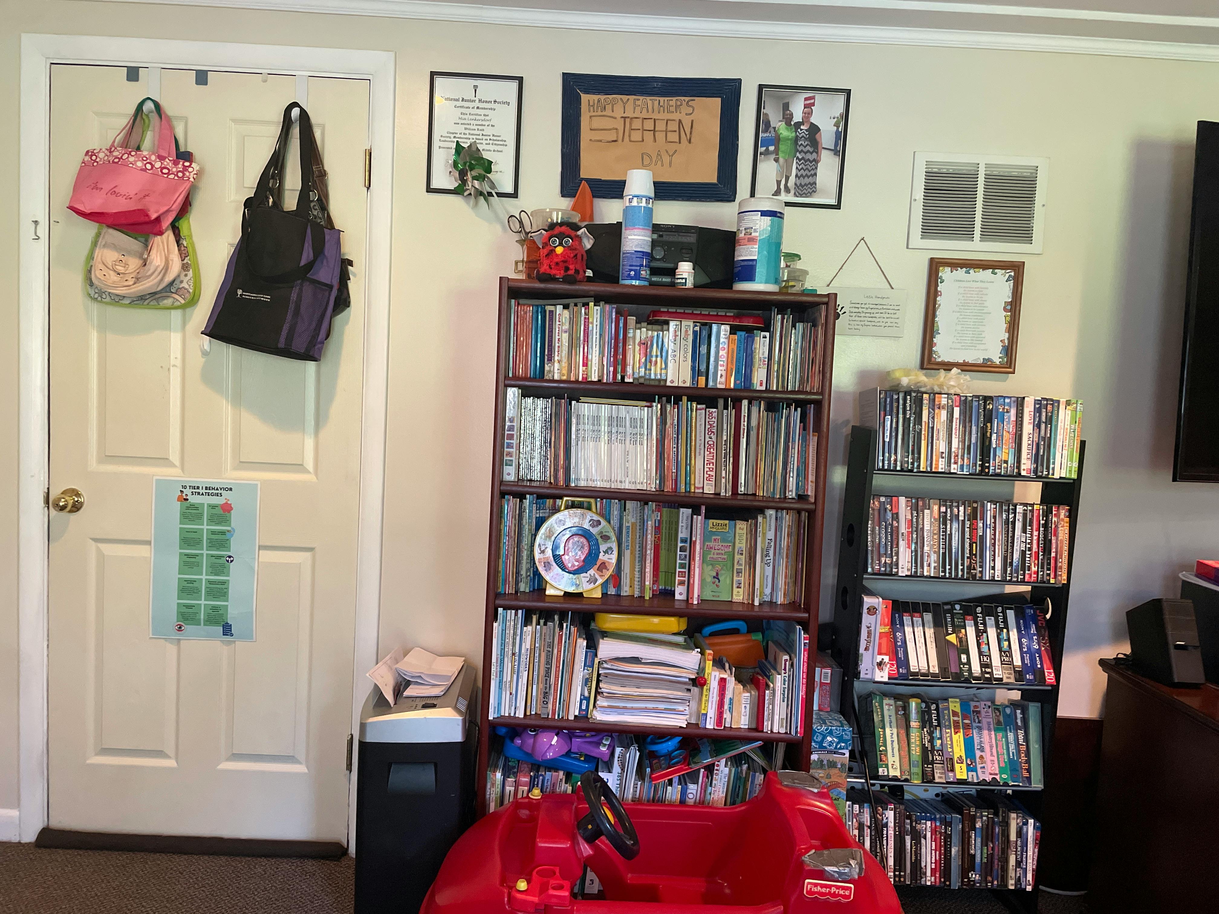 Two bookshelves filled with books and media next to a white door