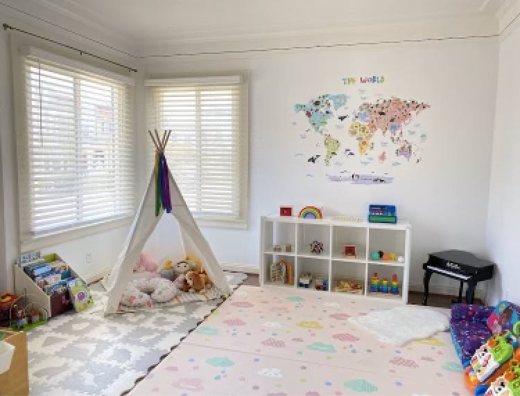 Playroom with a teepee, world map on the wall, and toy storage