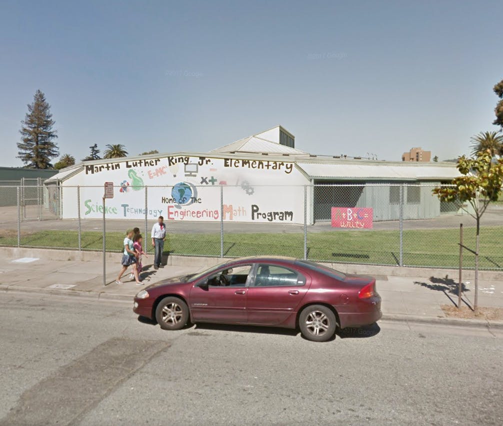 Martin Luther King Jr Elementary building with mural and parked car