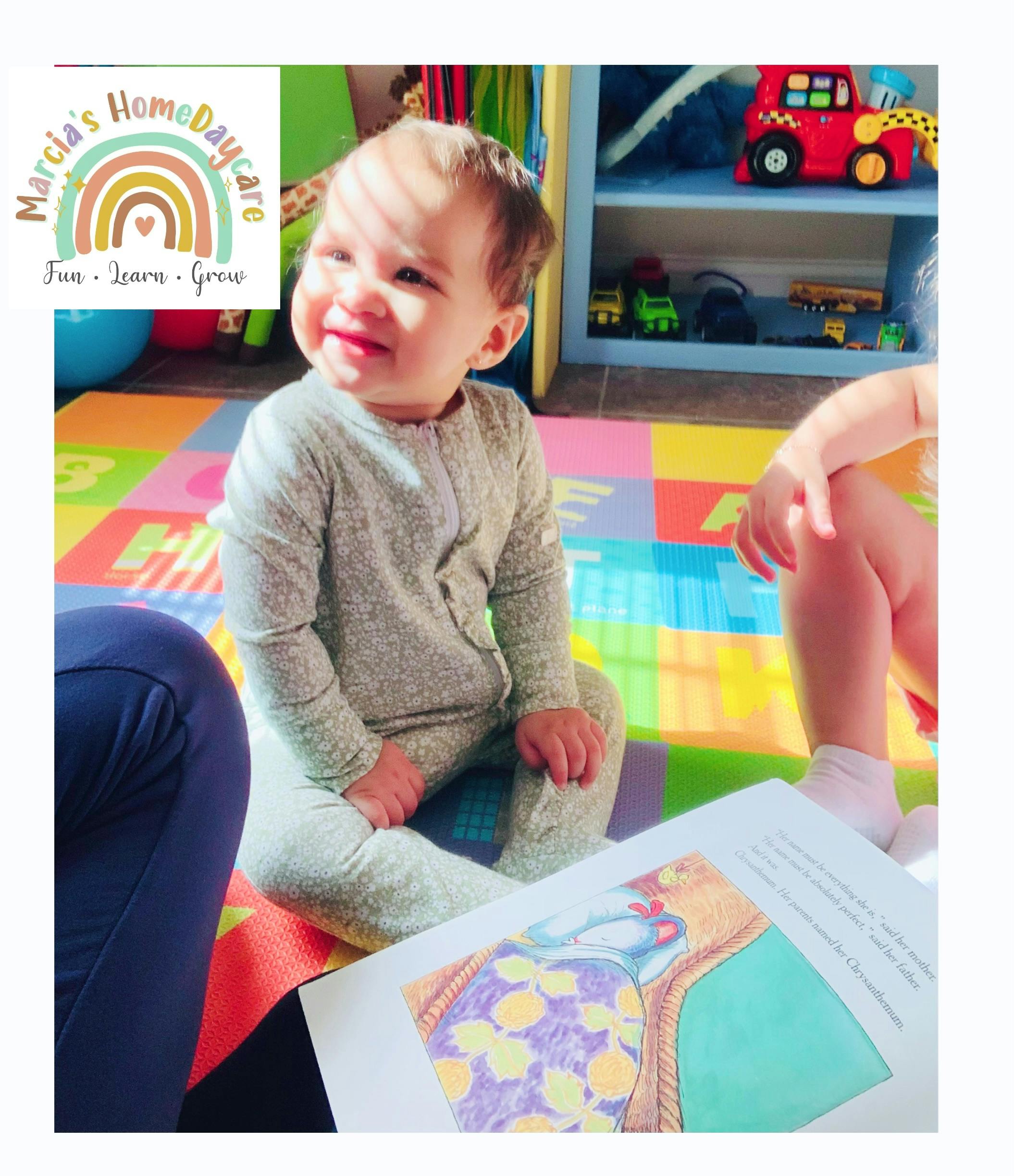 Child sitting on a colorful mat with an open book in front