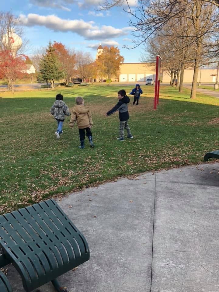 Four children playing in a grassy field