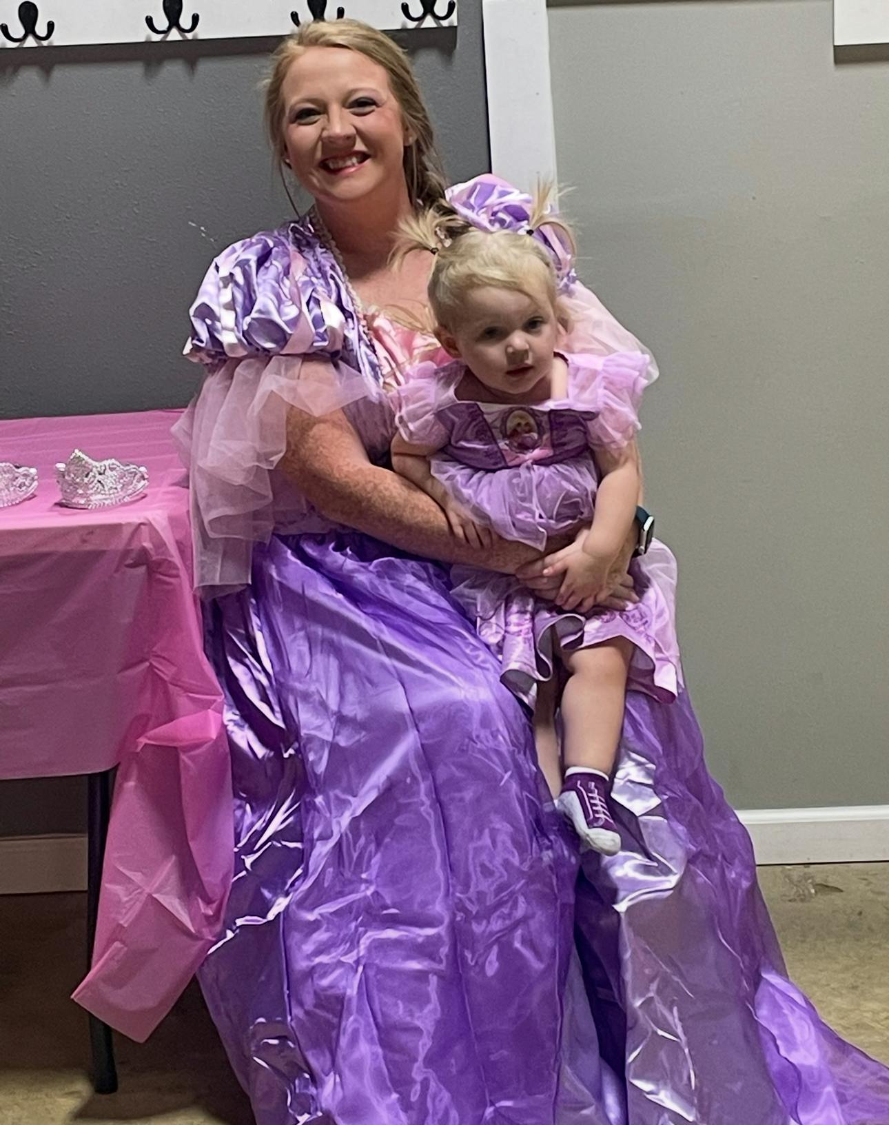 Person in purple dress holding a child in a purple dress