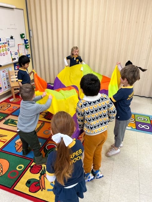 Children playing with a colorful parachute