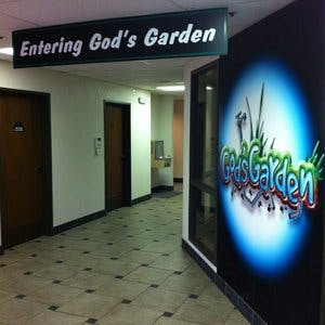 Hallway with a sign that reads "Entering God's Garden"