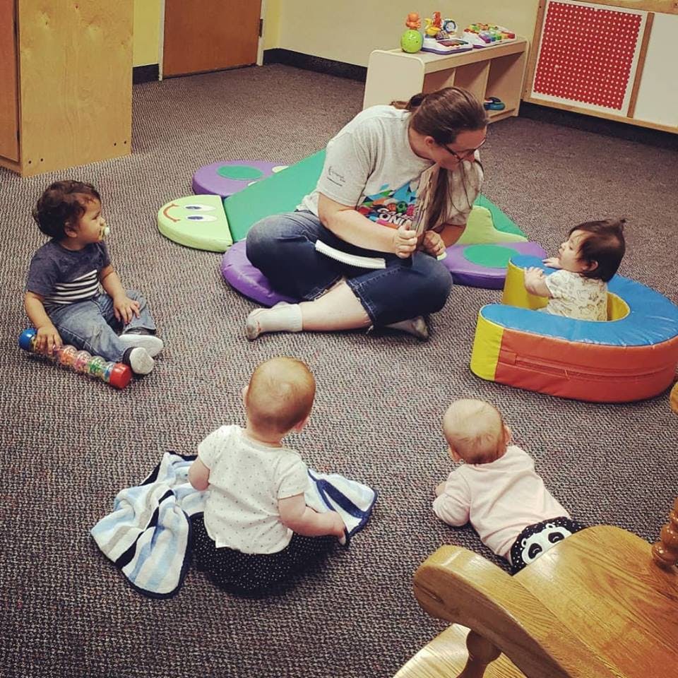 Person sitting on floor with four children
