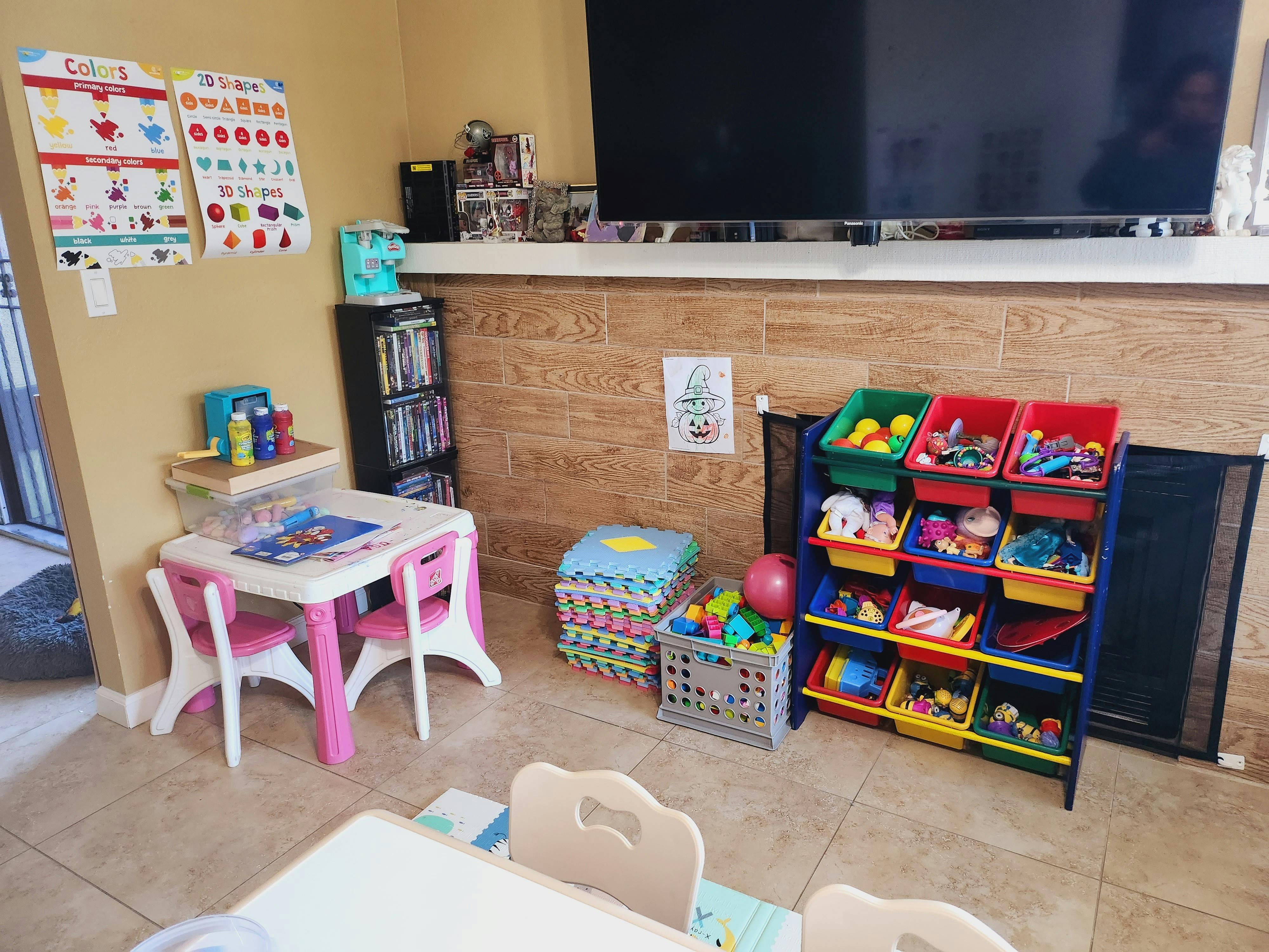 Children's play area with small table and chairs, toy storage unit