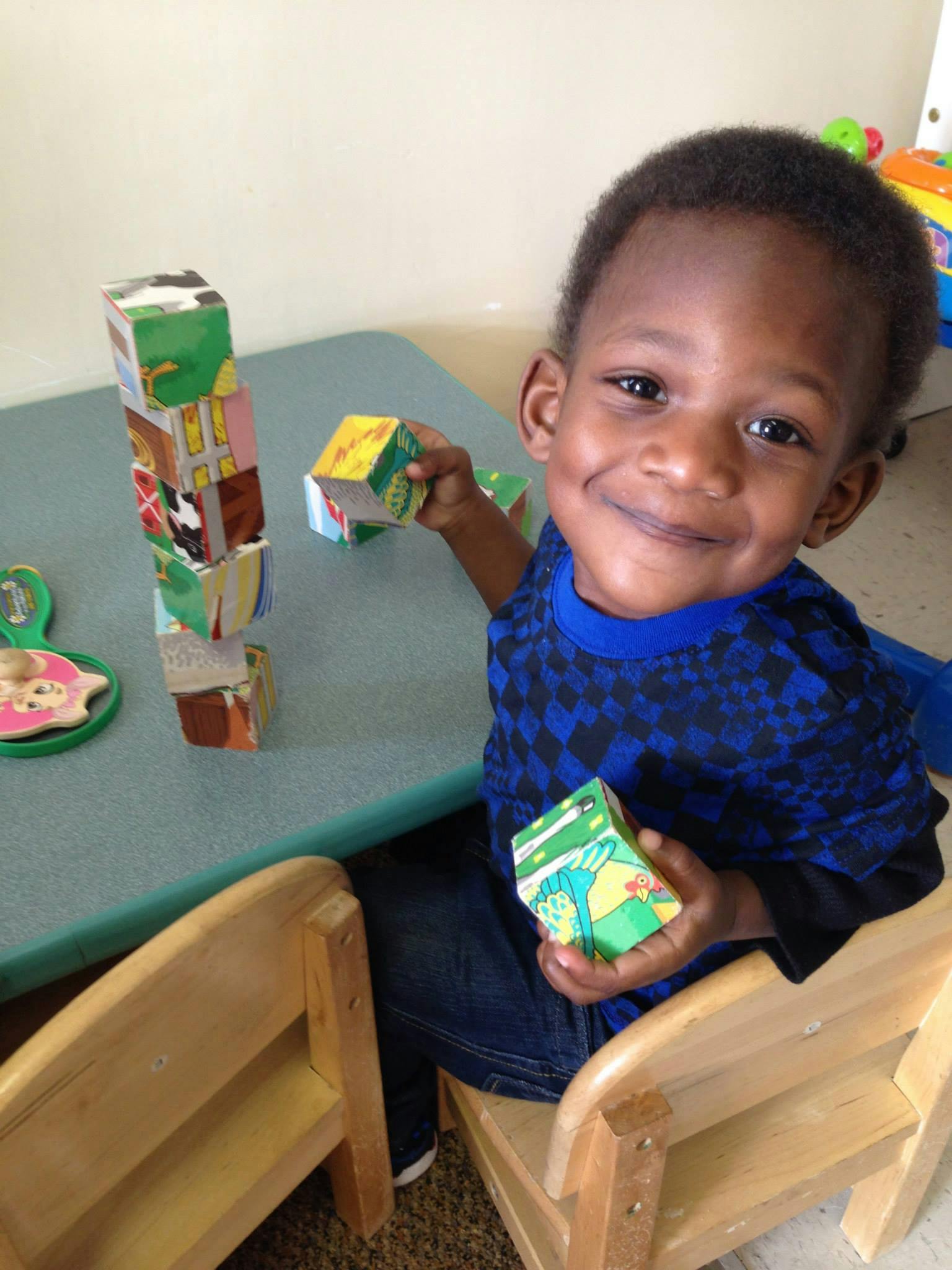 Child sitting at a table playing with blocks