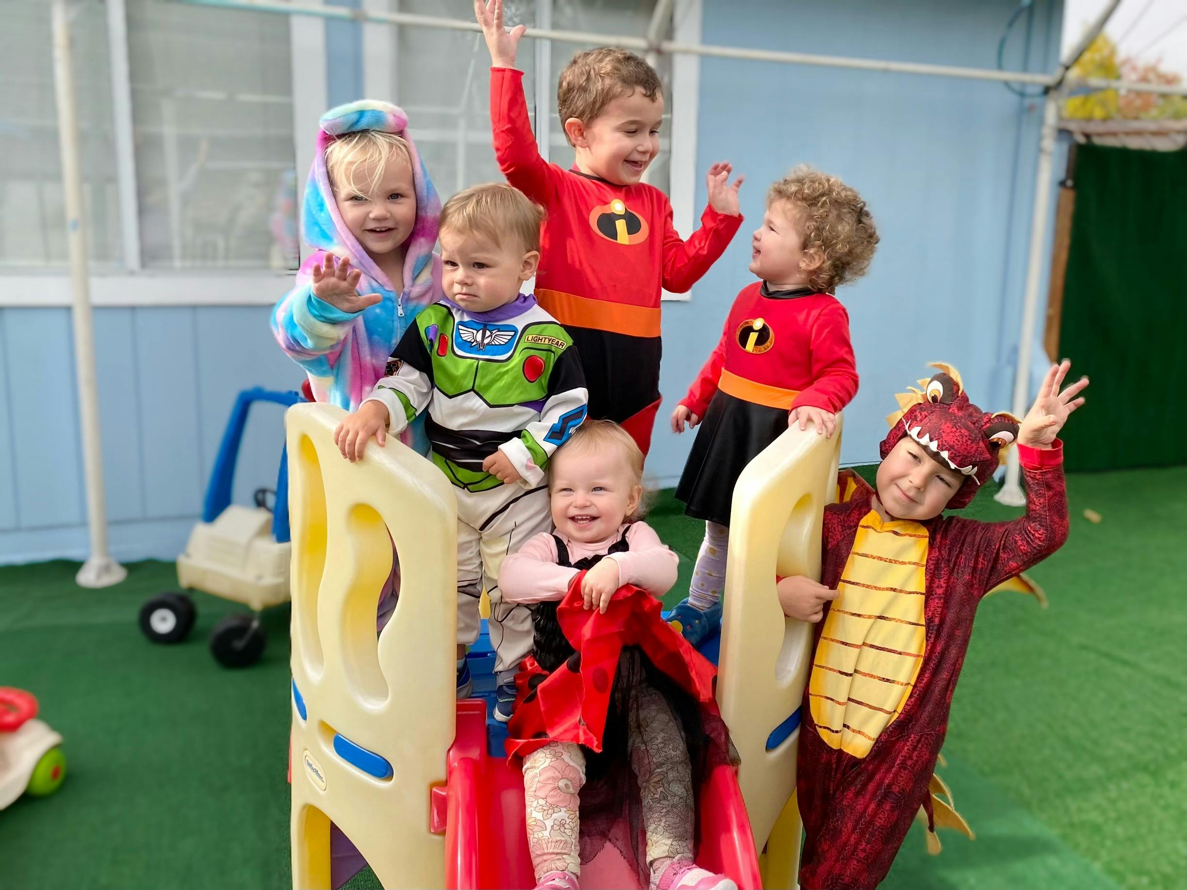 Children in costumes on a playground slide