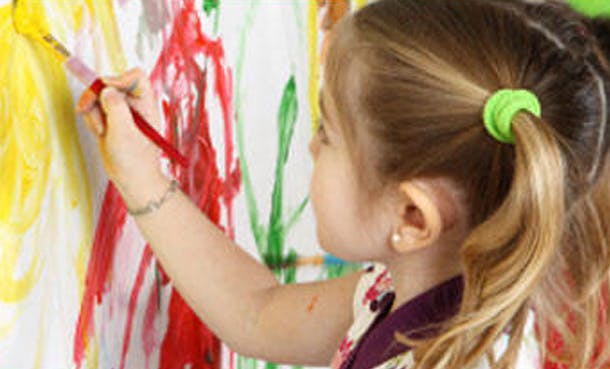 Child painting on a canvas with a brush