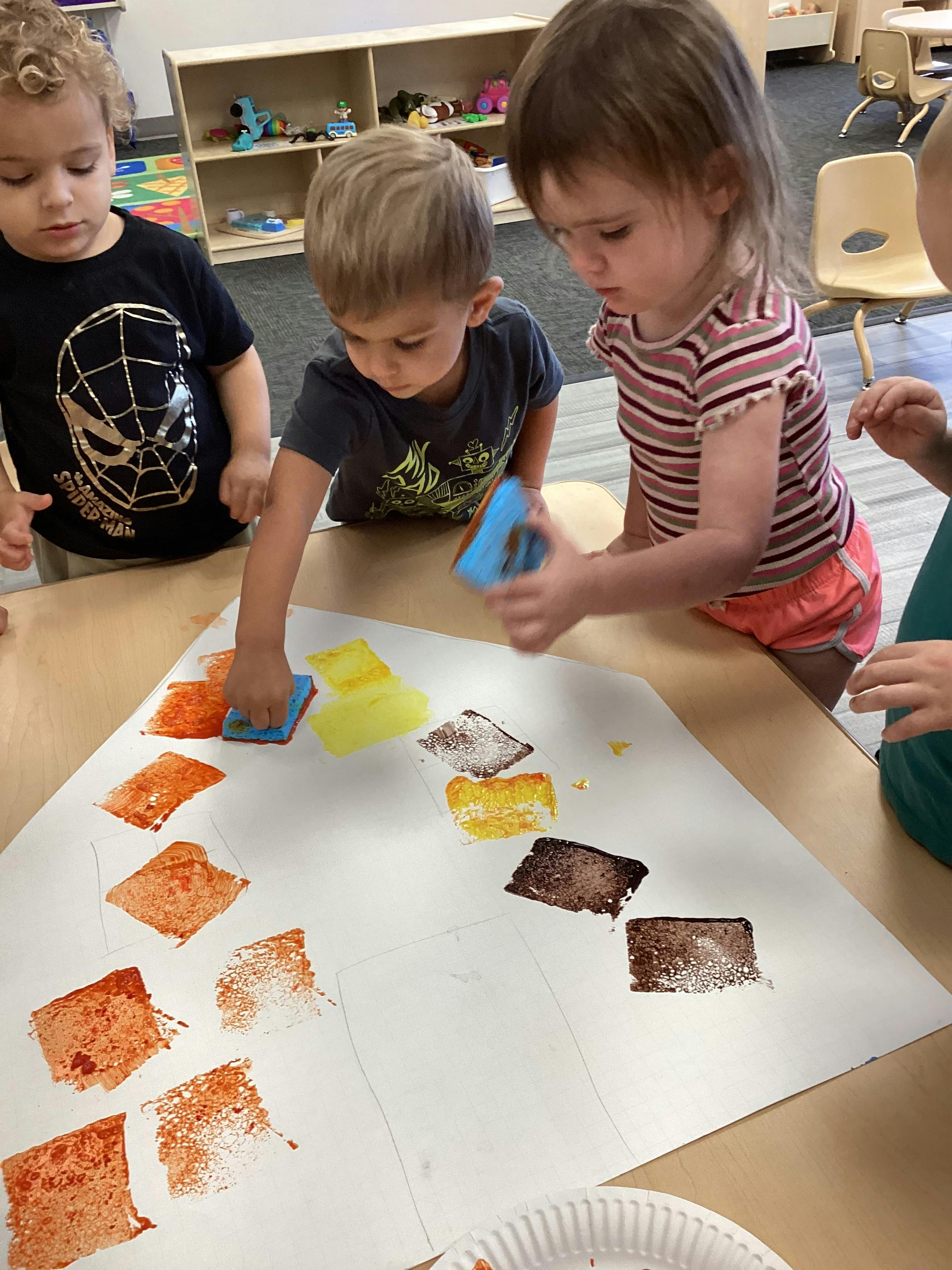 Children making art with sponges and paint