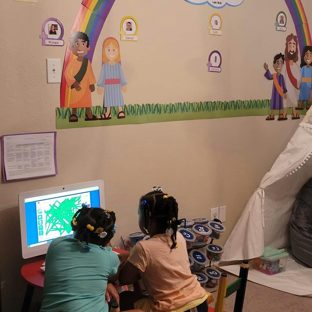 Two children looking at a computer screen