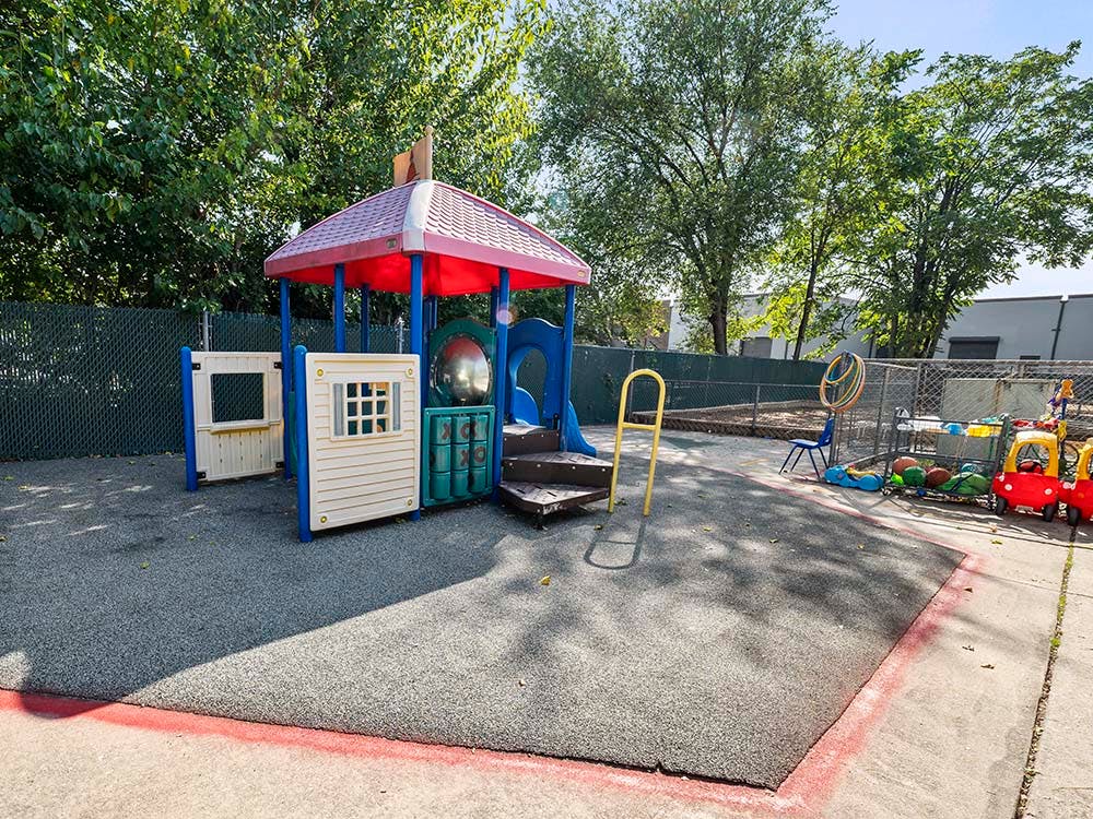 Empty outdoor playground with colorful play structure and toy cars