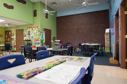 Classroom with tables and chairs, colorful walls, and decorations