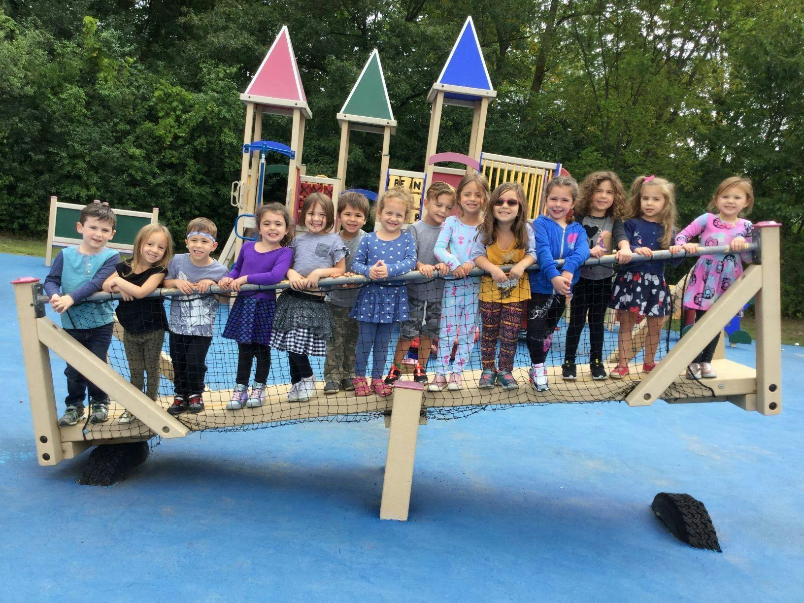 Group of children standing on a playground bridge