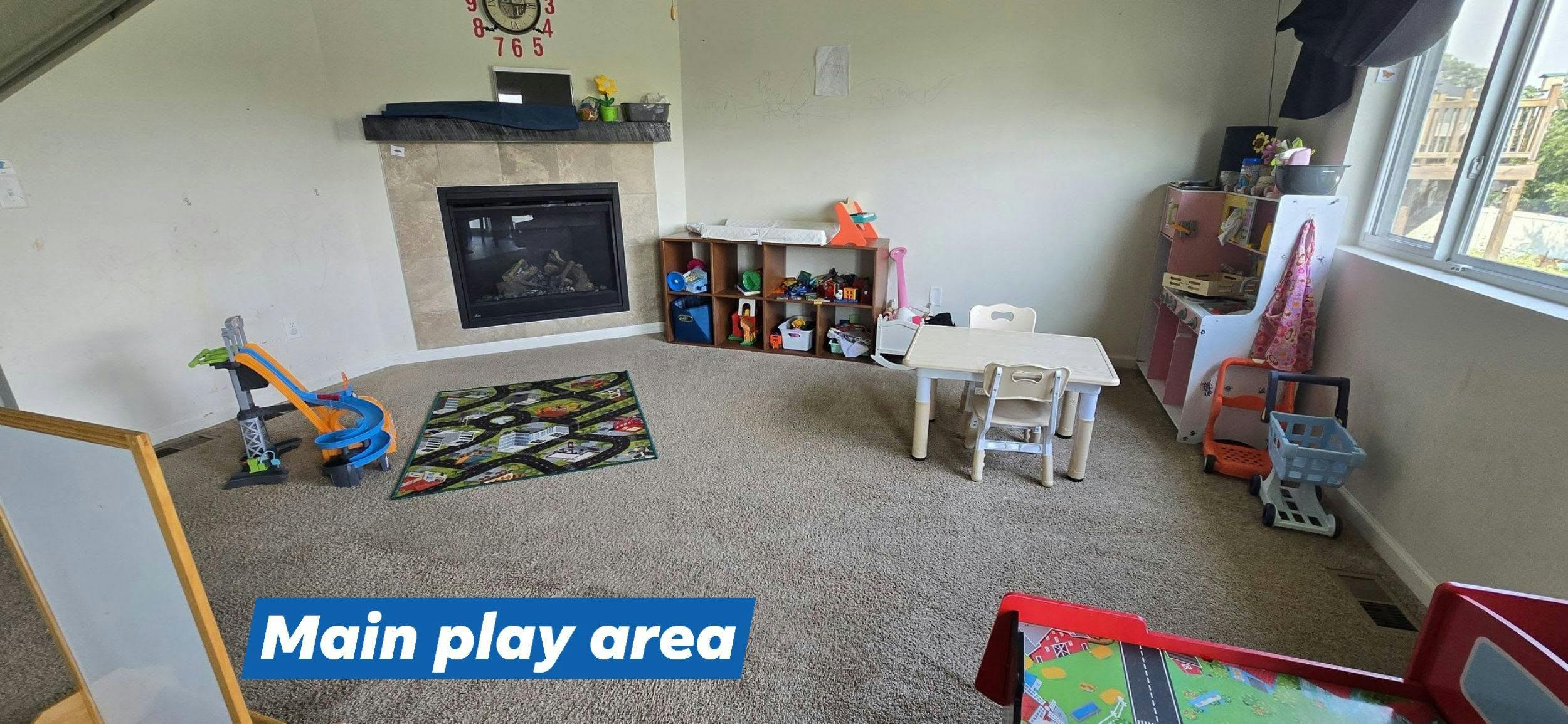 Child playroom with toys and a small table near a fireplace