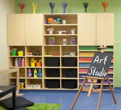 Art studio with shelves of supplies and an easel with "Art Studio" written on it