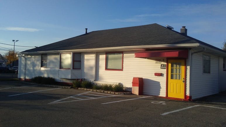White building with a yellow door and red awning