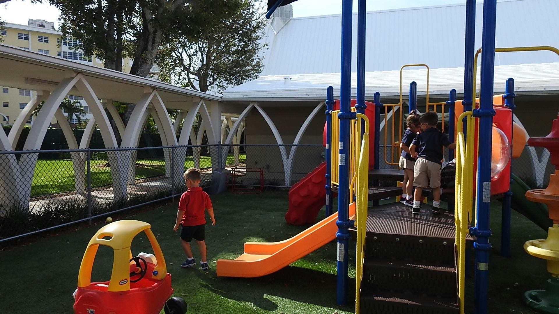Children playing on a playground with slides and climbing structures