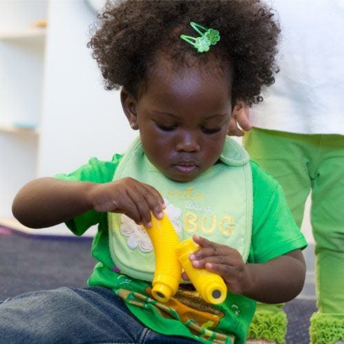 Child playing with a yellow toy