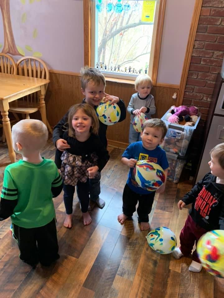 Group of children holding and playing with colorful balloons indoors