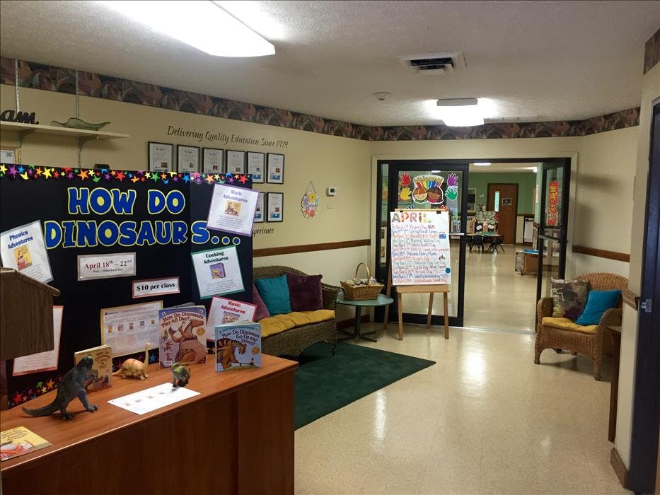 Lobby area with a display board titled "How Do Dinosaurs..." and books