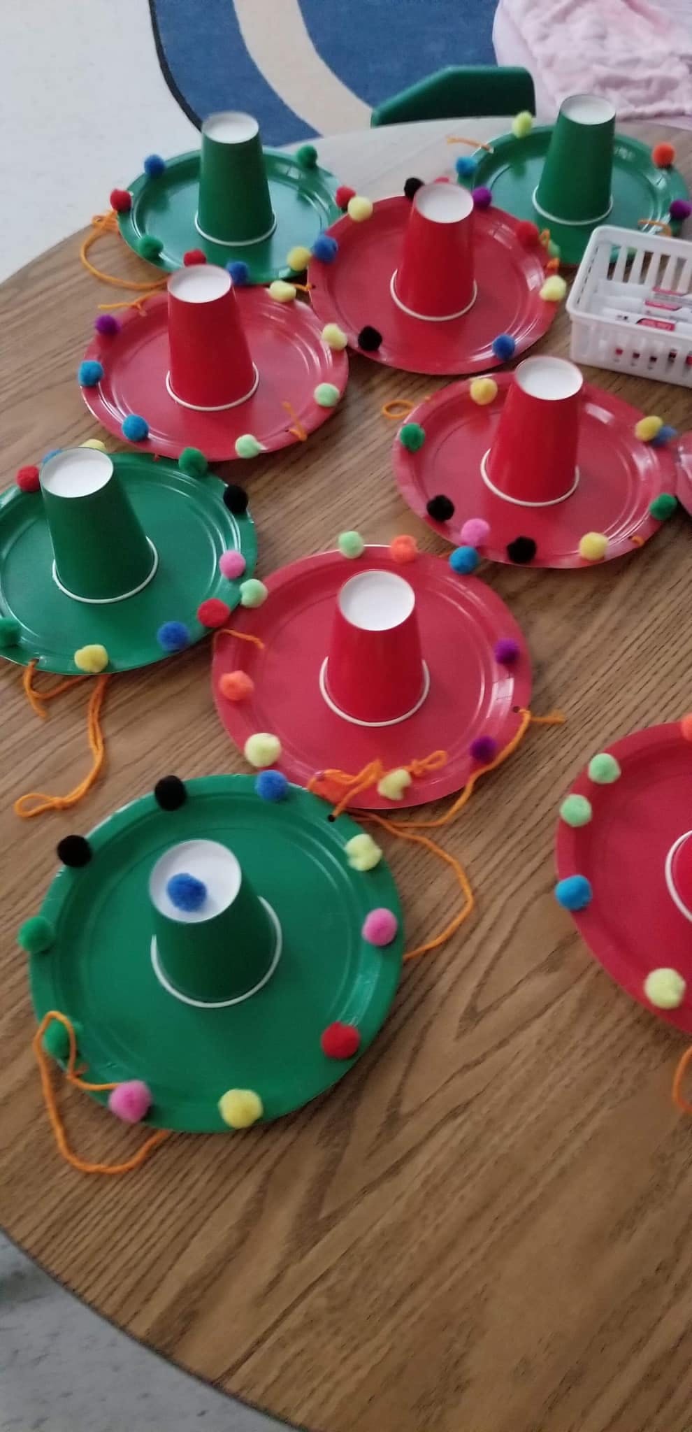 Crafts made from paper plates and cups decorated with pom-poms