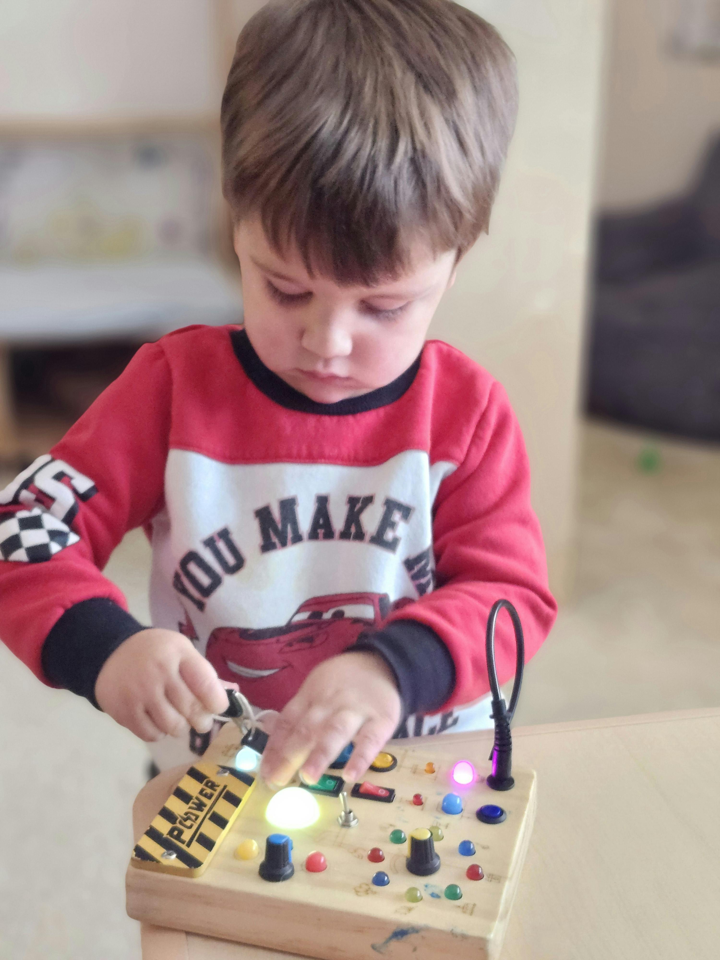 Child playing with a light-up activity board