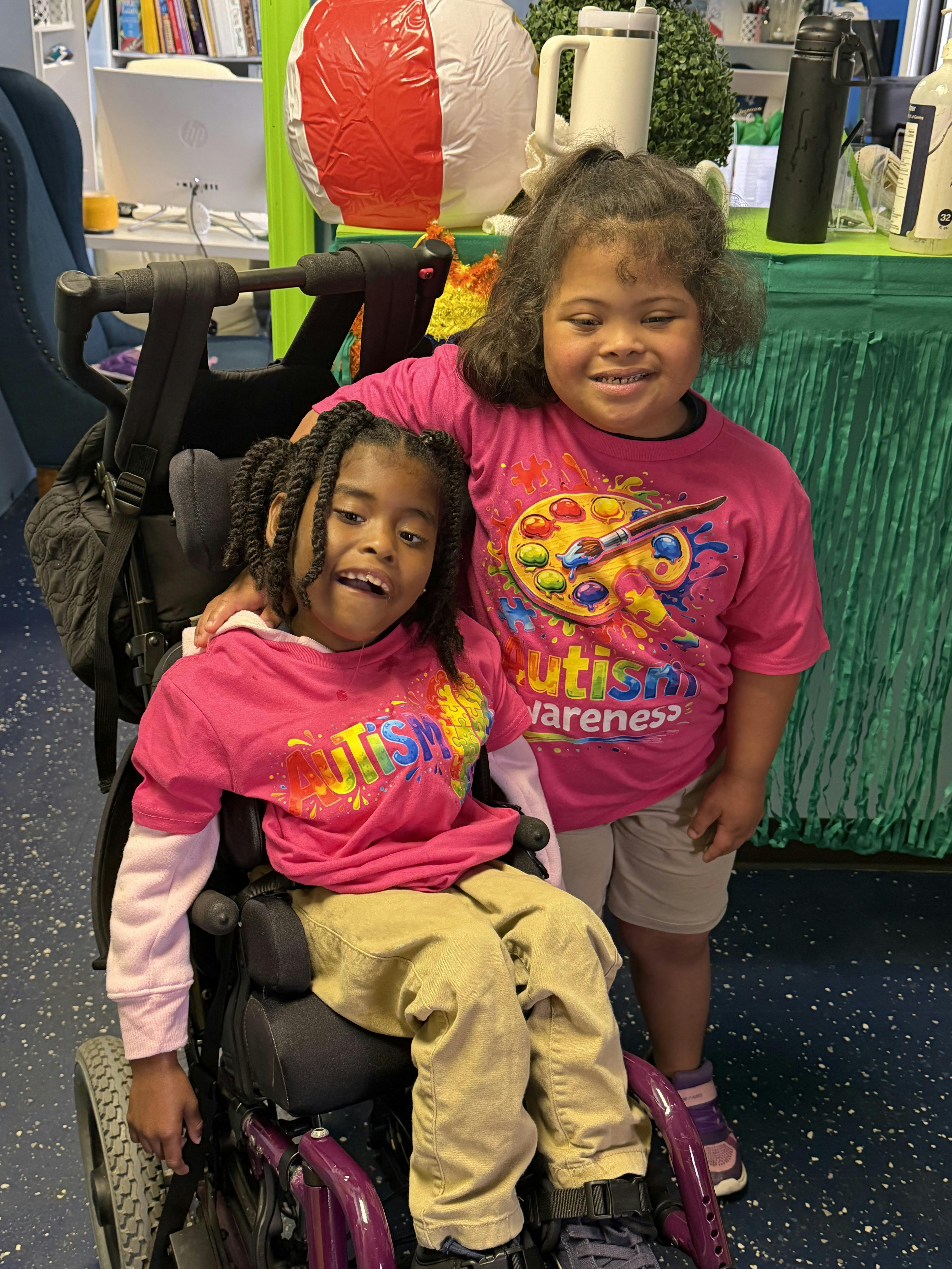 Two children in pink "Autism Awareness" shirts