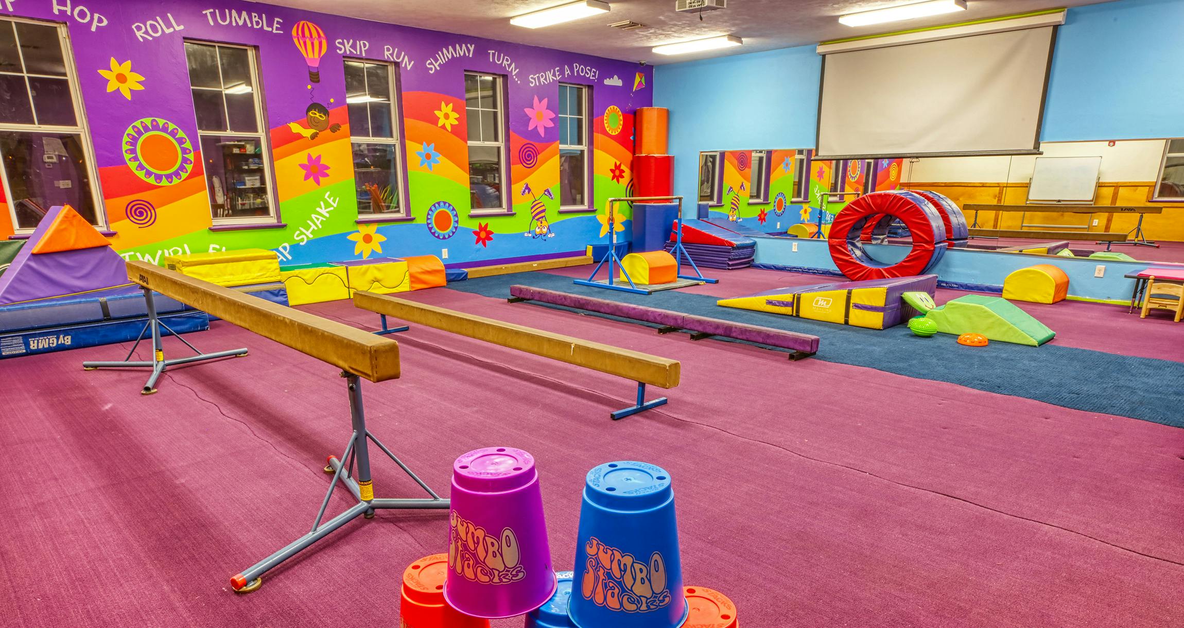 Colorful indoor children's play gym with balance beams and soft play equipment