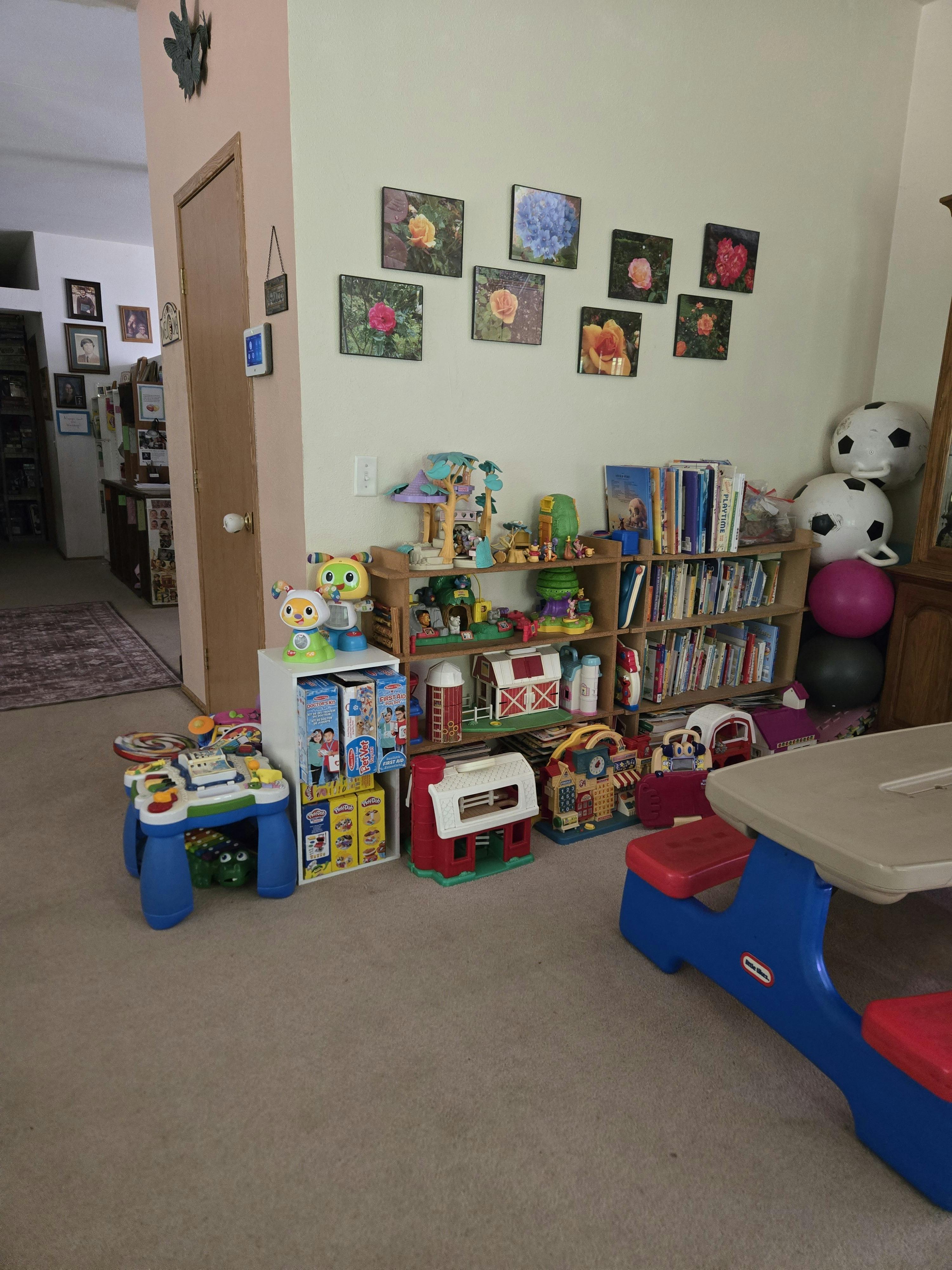 Playroom with shelves full of toys and books and a small children table