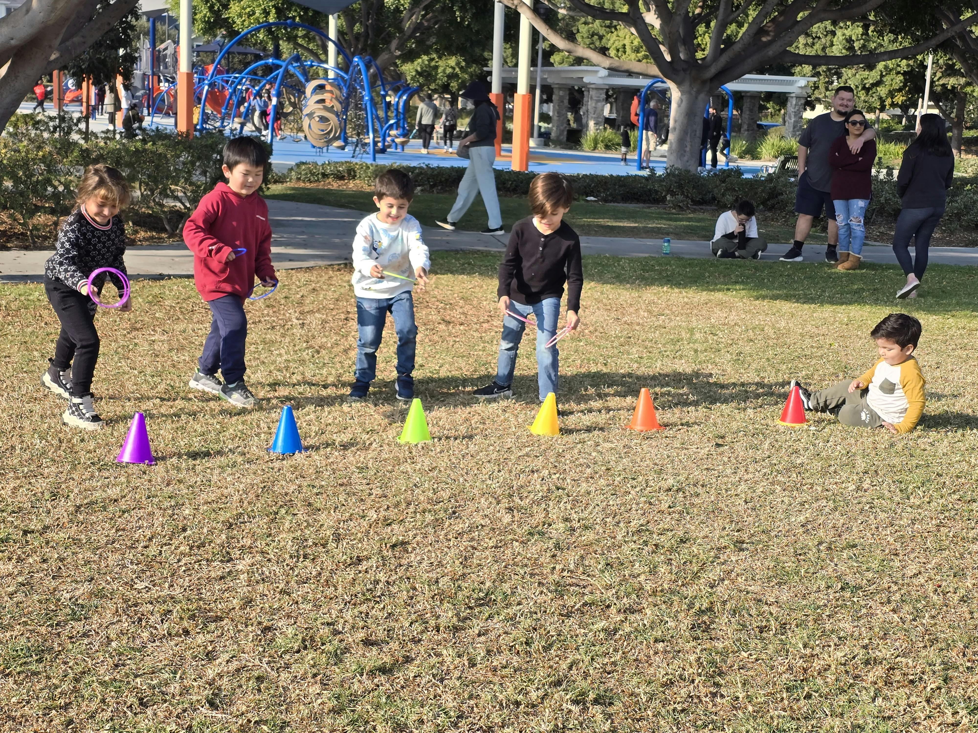 Children playing with colorful cones on a grassy field